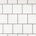 Białe fugi łazienkowe na jasnych płytkach ceramicznych.