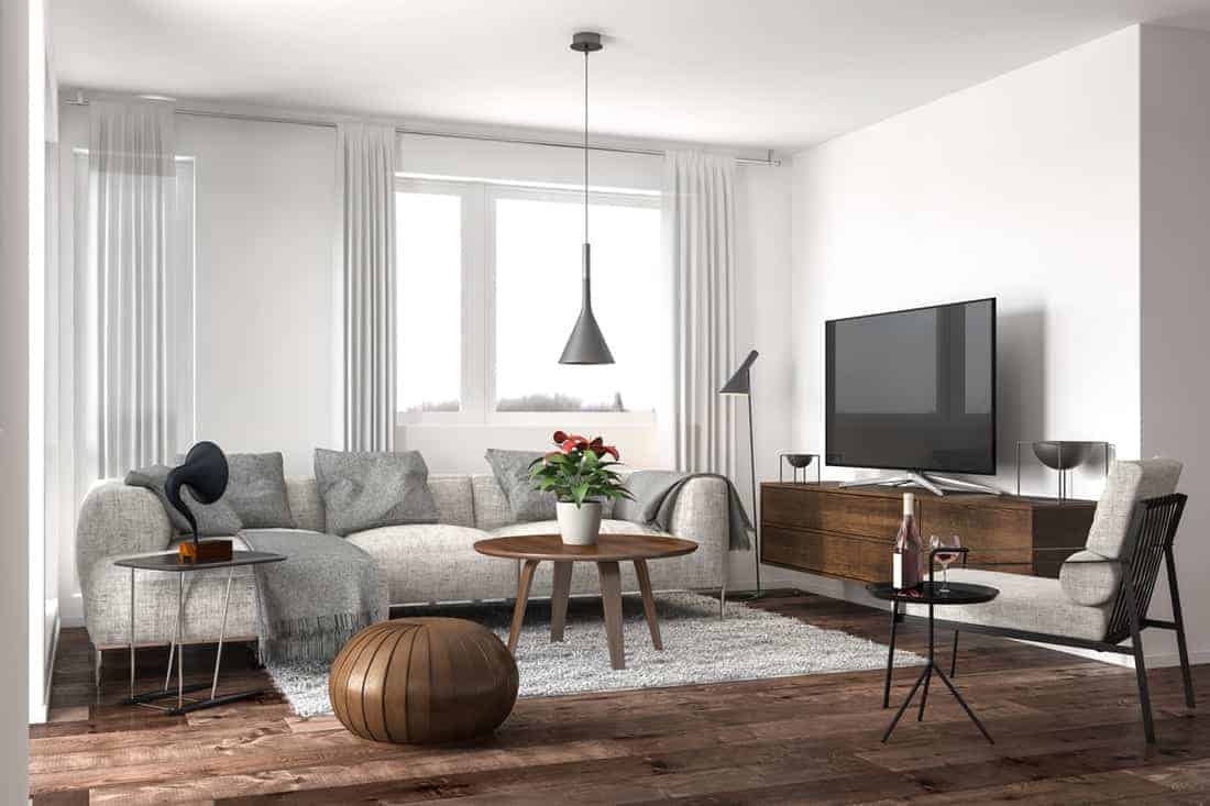 Przestronny salon z dużymi oknami, minimalistycznym wystrojem i wygodną sofą.
