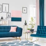 Stylowa niebieska sofa i fotel w nowoczesnym salonie z dekoracjami.