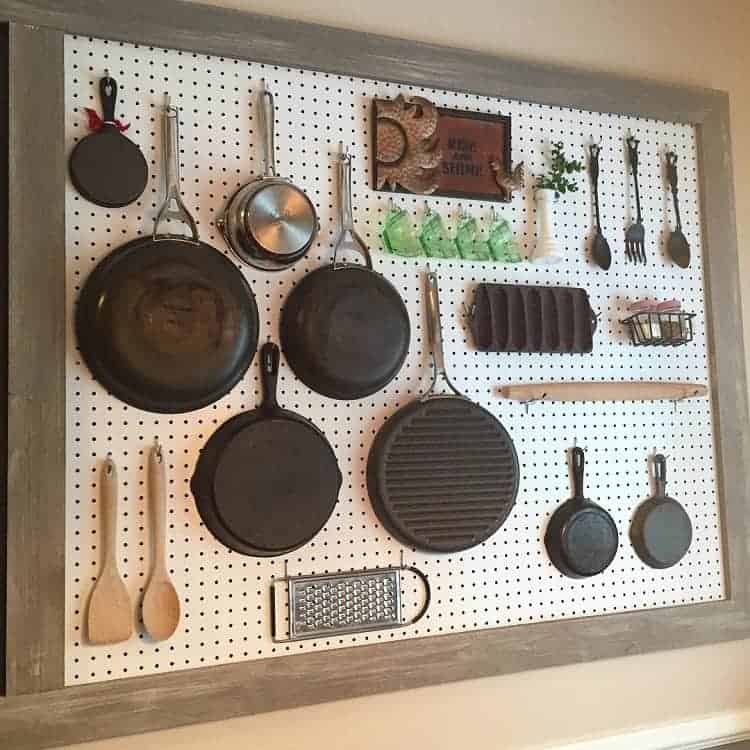 Przechowywanie naczyń i akcesoriów na tablicy pegboard w kuchni.