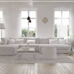 Przestronny biały salon z dużą sofą i naturalnym światłem.