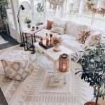 Przytulny biały salon w stylu Boho z roślinami i dekoracjami.