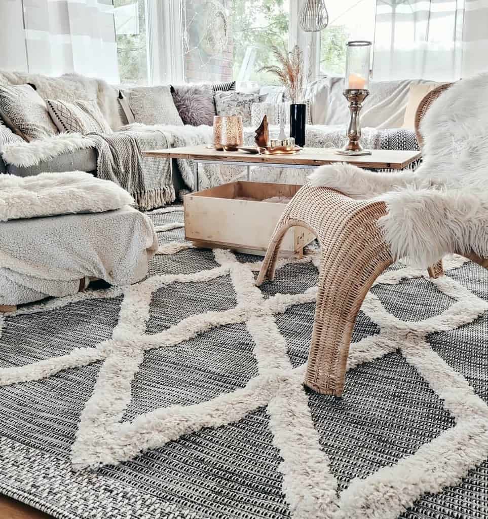 Przytulny biały salon w stylu Boho z miękkimi poduszkami i dywanem.