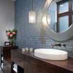 Łazienka z niebieskimi płytkami Backsplash i eleganckim lustrem.