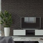 Nowoczesny wiszący stojak na telewizor w salonie z czarną ścianą.