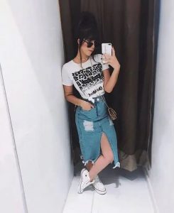 Stylowa kobieta w dżinsowej spódnicy midi i t-shircie z leopardim wzorem.
