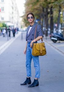 Stylowa kobieta w modnej przyciętej marynarce na ulicy wiosną.