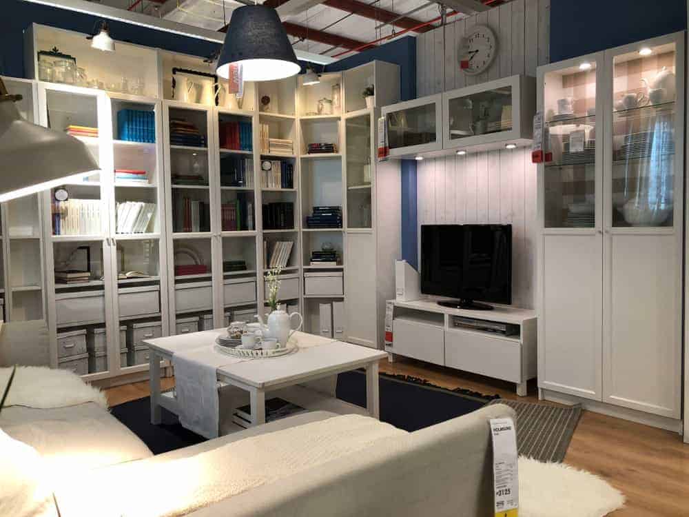 Przykład nowoczesnego salonu z mebli IKEA i białymi regałami.