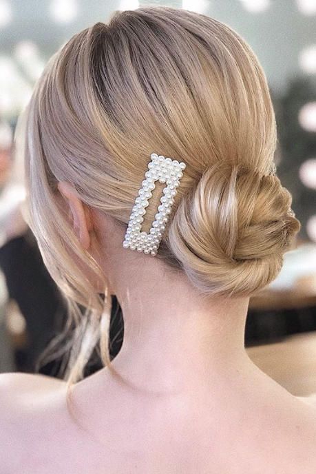 Elegancka mama z perłową spinką do włosów na upięciu.