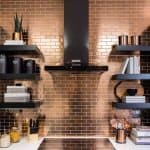 Kuchnia z brązowymi płytkami backsplash i czarnymi półkami.