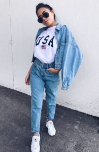Modna kobieta w jeansowej kurtce i spodniach, okulary przeciwsłoneczne, casualowy look.