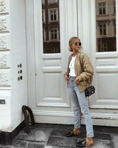 Kobieta w oversize bomberce, jeansach i botkach na jesień.