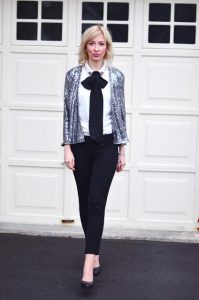 Stylowa kobieta w cekinowej kurtce i eleganckim stroju.