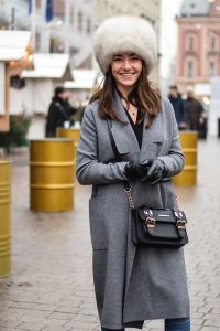 Kobieta w miękkim futrzanym czepku i eleganckim płaszczu.