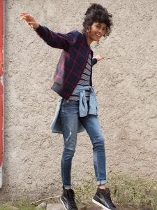 Kobieta w kurtce bomber w kratkę, casualowa stylizacja, młoda mama, inspiracje modowe.