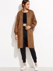 Kobieta w brązowym płaszczu na zamek, casualowy look.