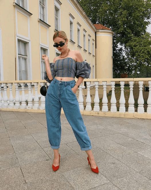 Stylizacja z szerokimi jeansami baggy, krótkim topem i czerwonymi szpilkami.